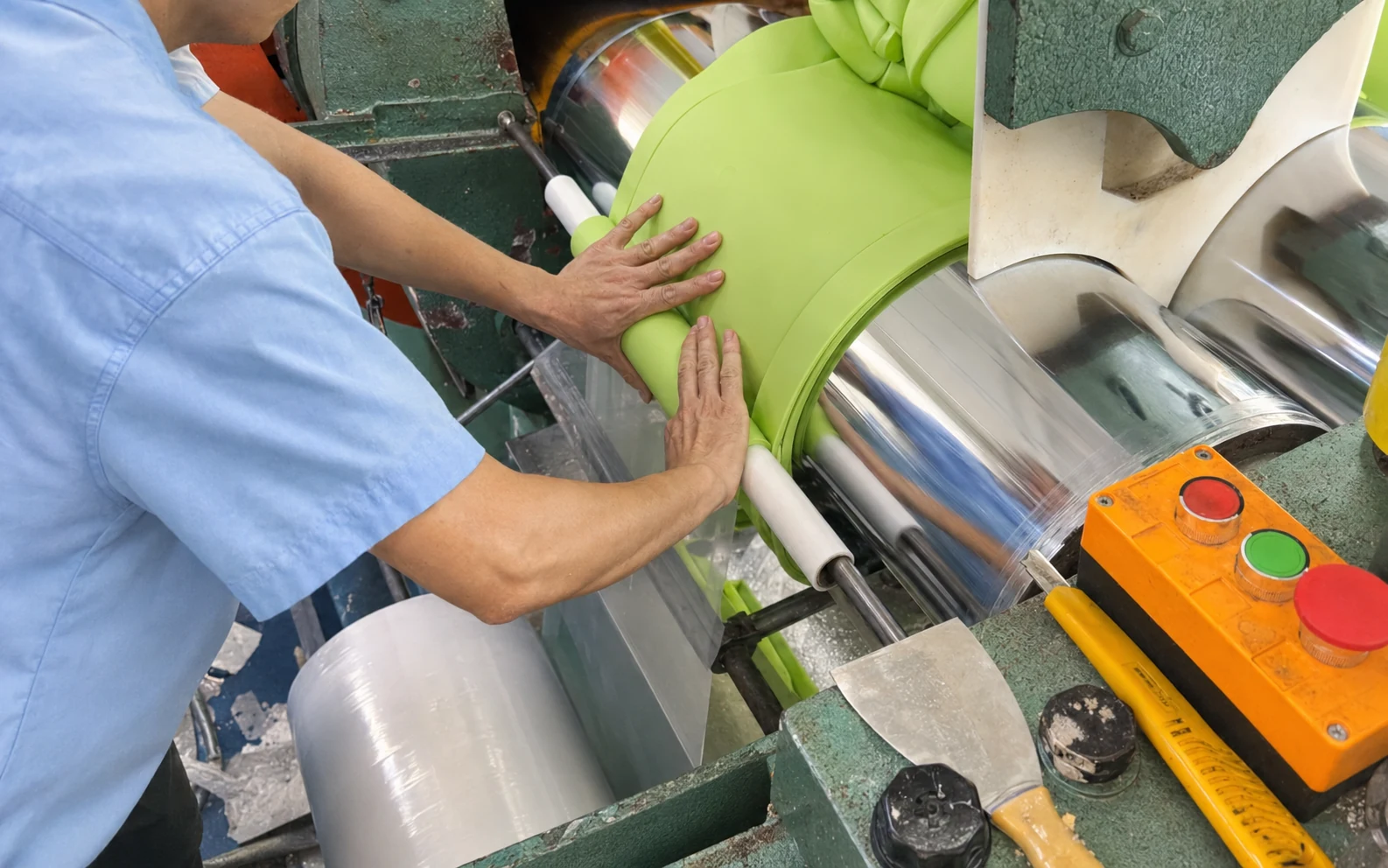 Operator preparing silicone material on mixing rollers